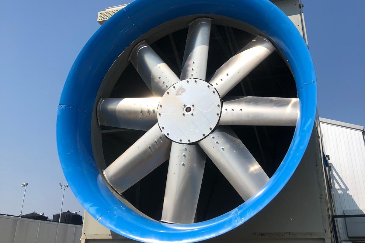 A blue E-Bell™ inlet bell on an eight blade axial fan, seen from below against a clear sky