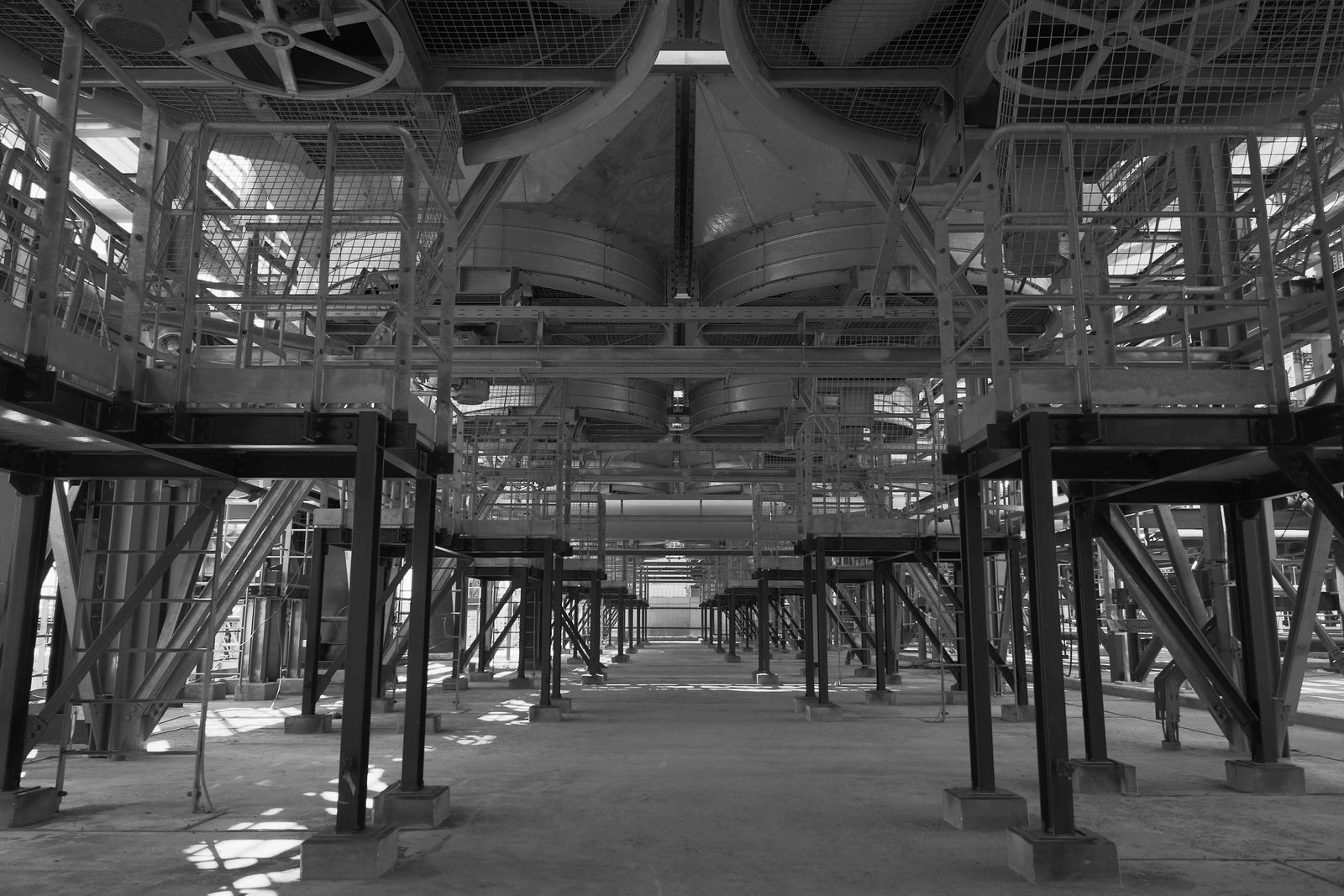 Looking down the walkway under a forced draft air cooled heat exchanger bank, fans and plenums overhead