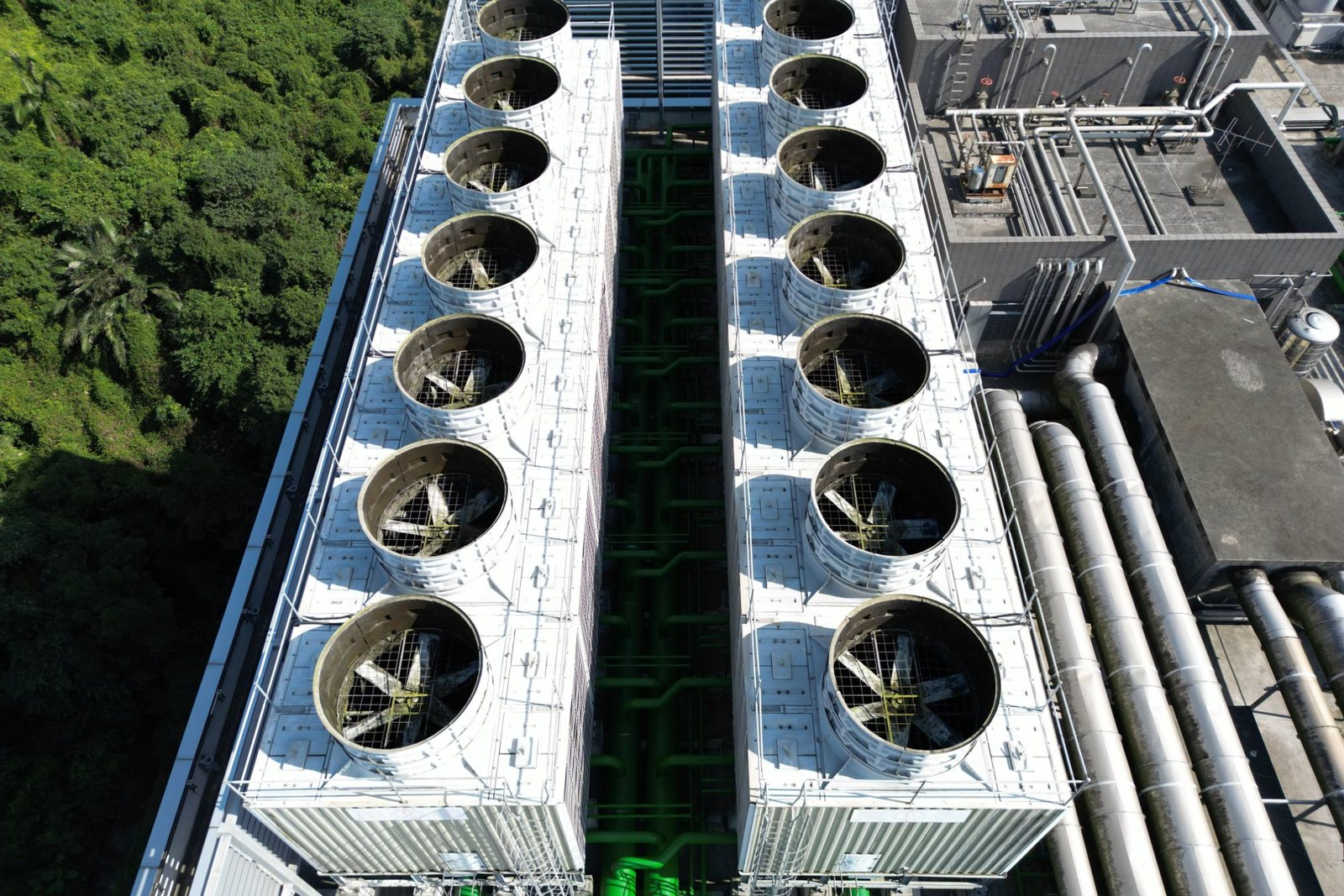 Aerial view of a long double row of cooling tower cells, each with its own axial fan